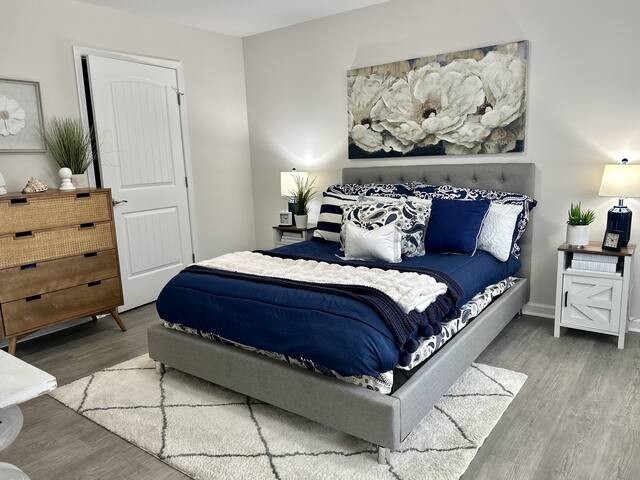 Bedroom with staged navy bed and artwork